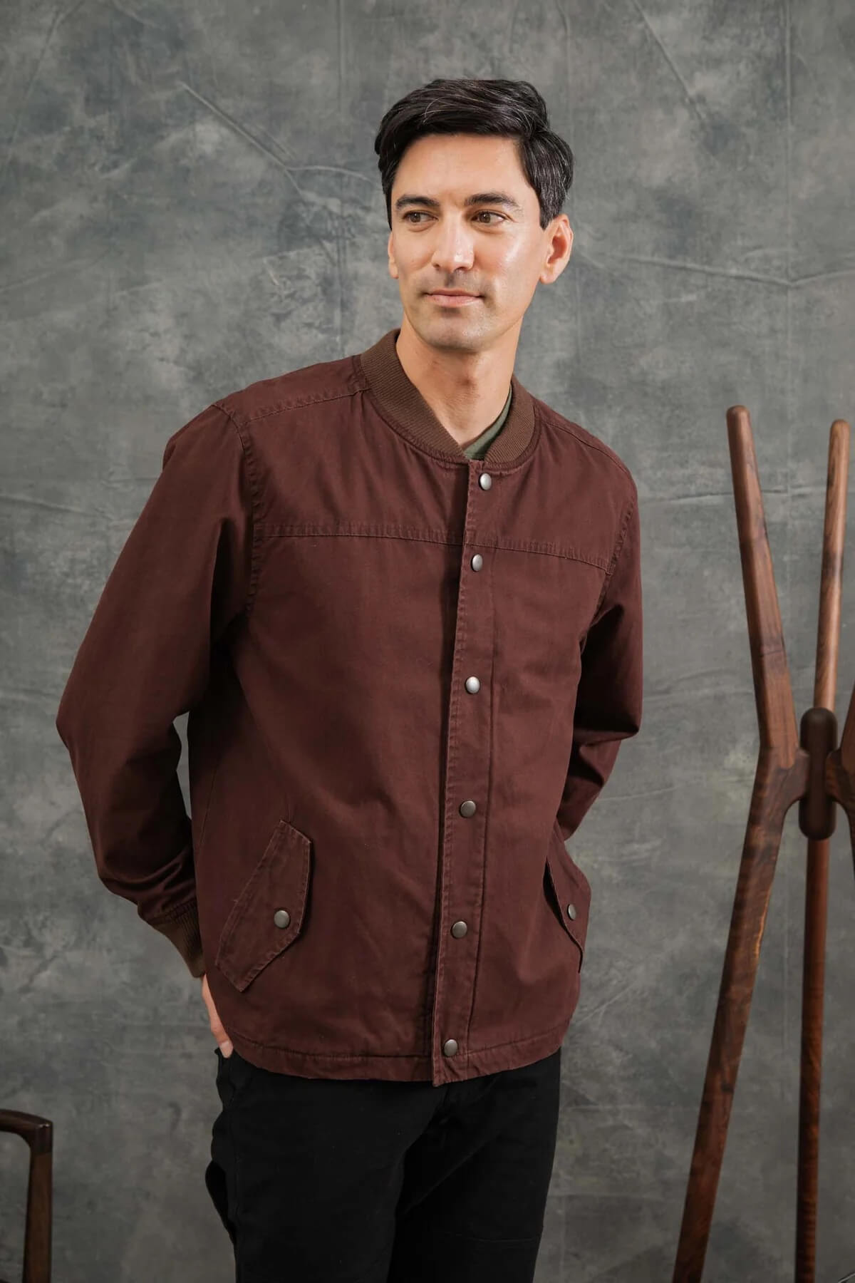 Man wearing the Bridge and Burn Austen Varsity Jacket in mahogany canvas
