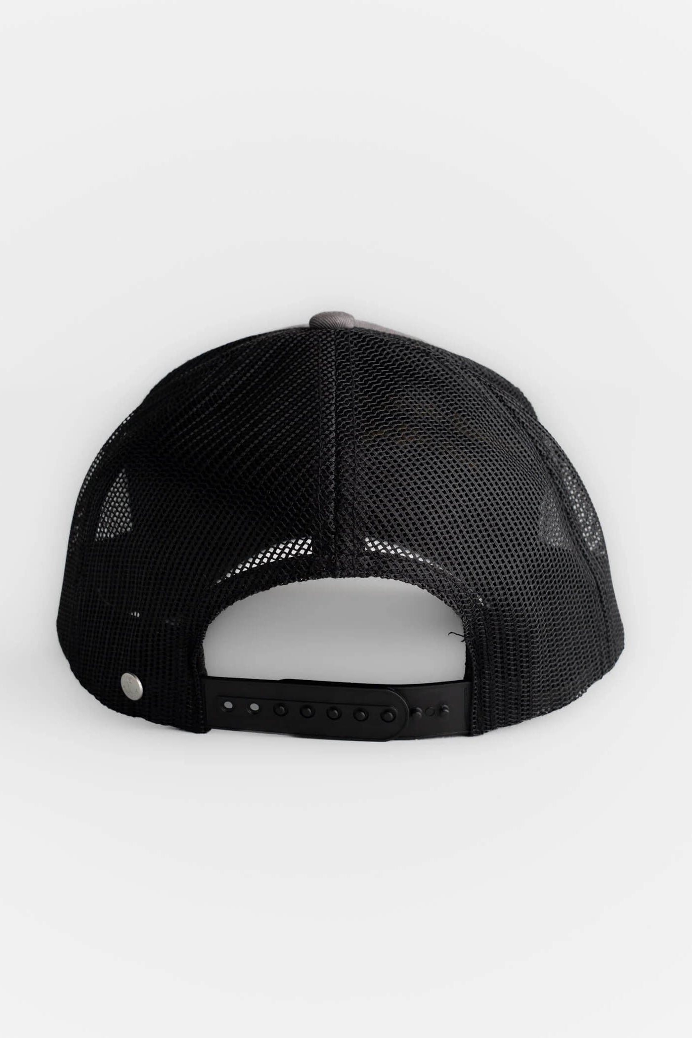 Black trucker-style baseball cap viewed from the back, featuring a black mesh back and an adjustable snap closure, set against a plain light gray background.