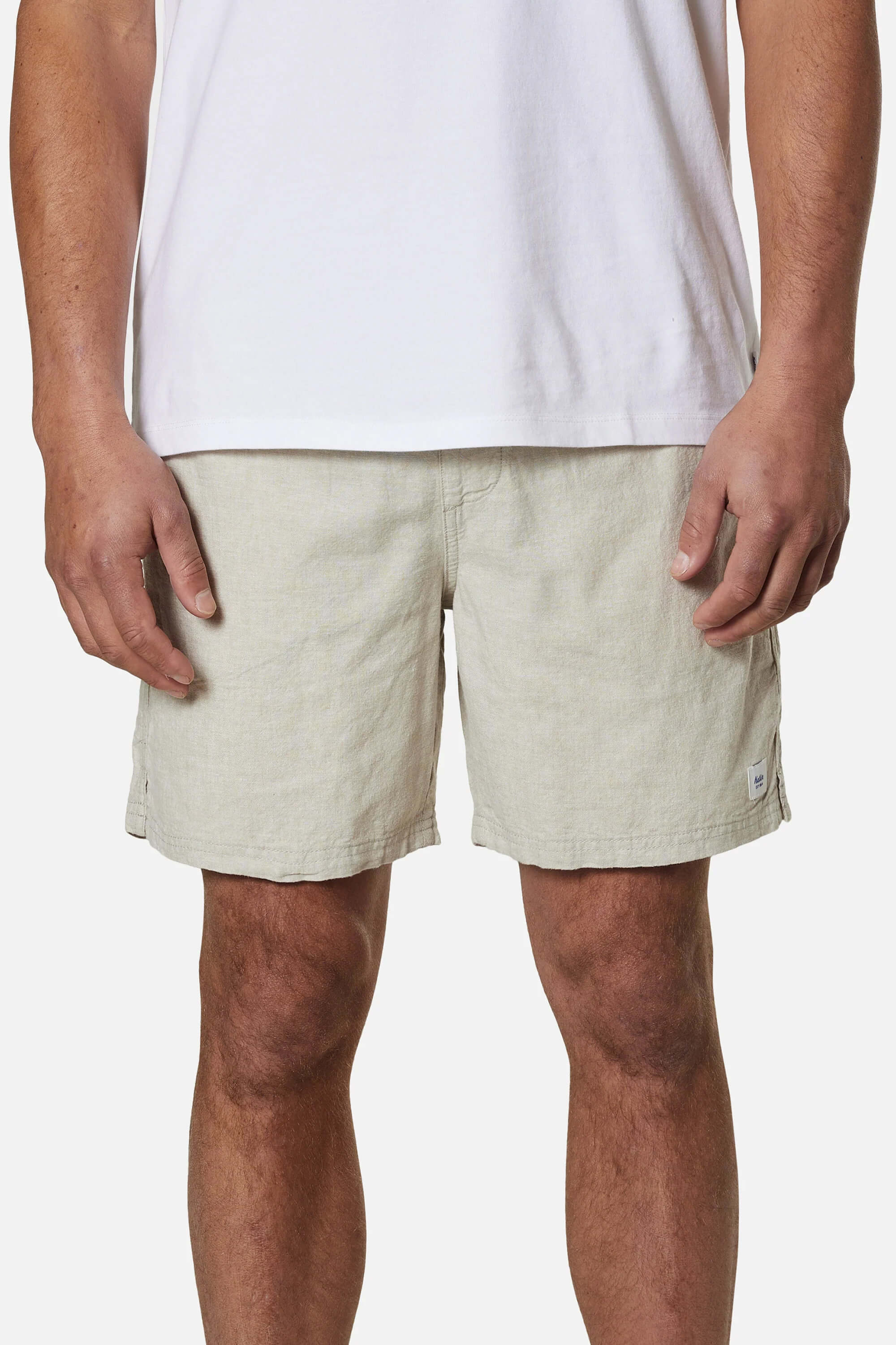 Person wearing beige shorts and a white shirt on a white background