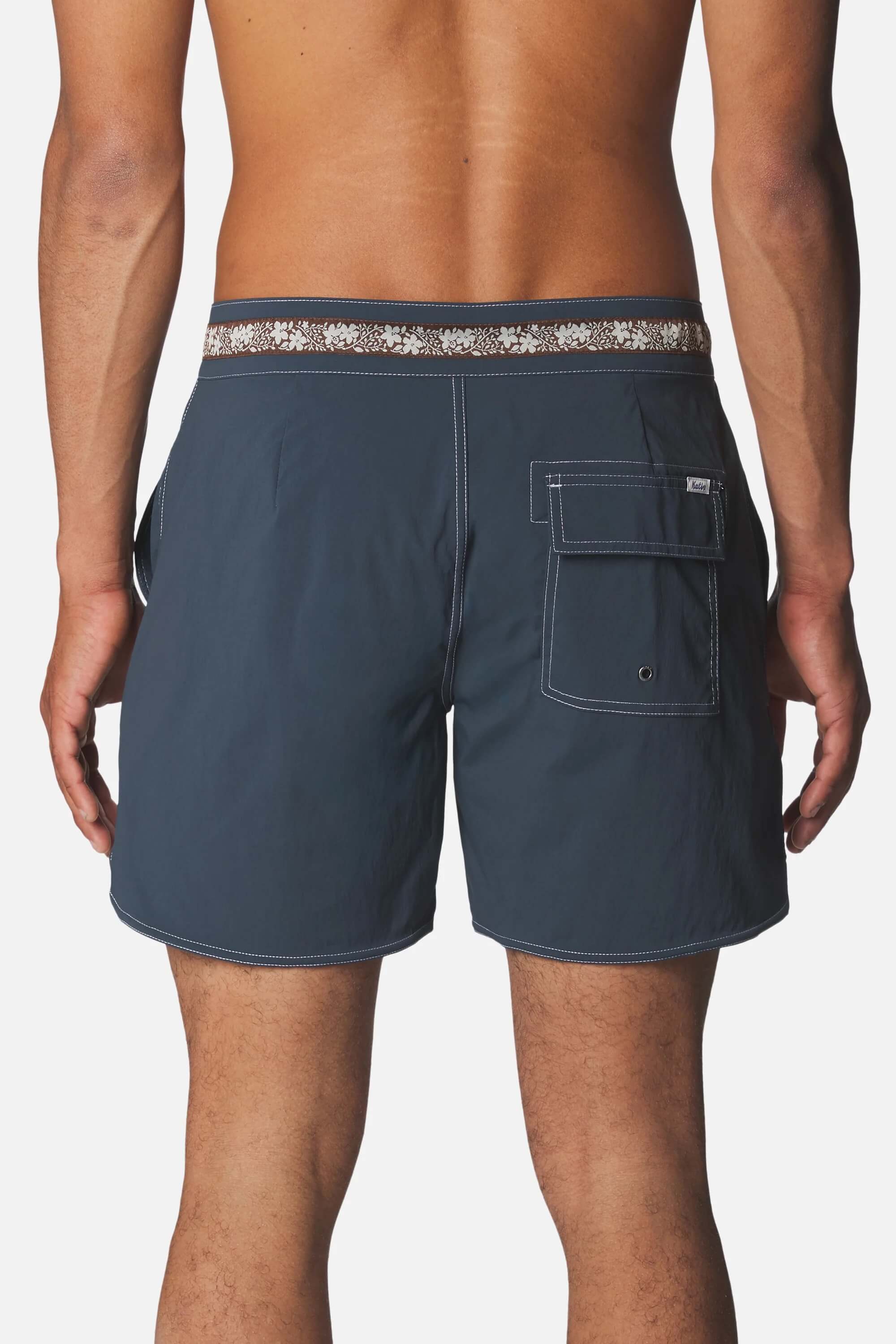 Rear view of a man wearing Katin Snapper Hybrid Trunk in Sea Storm, against a light gray background.