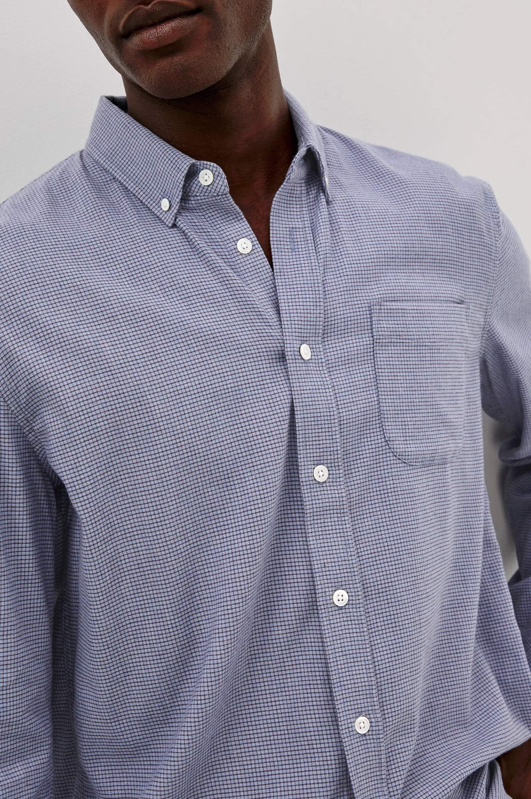 Close-up of a person wearing Rails Vance shirt in Blue Heather Grid with a plain background