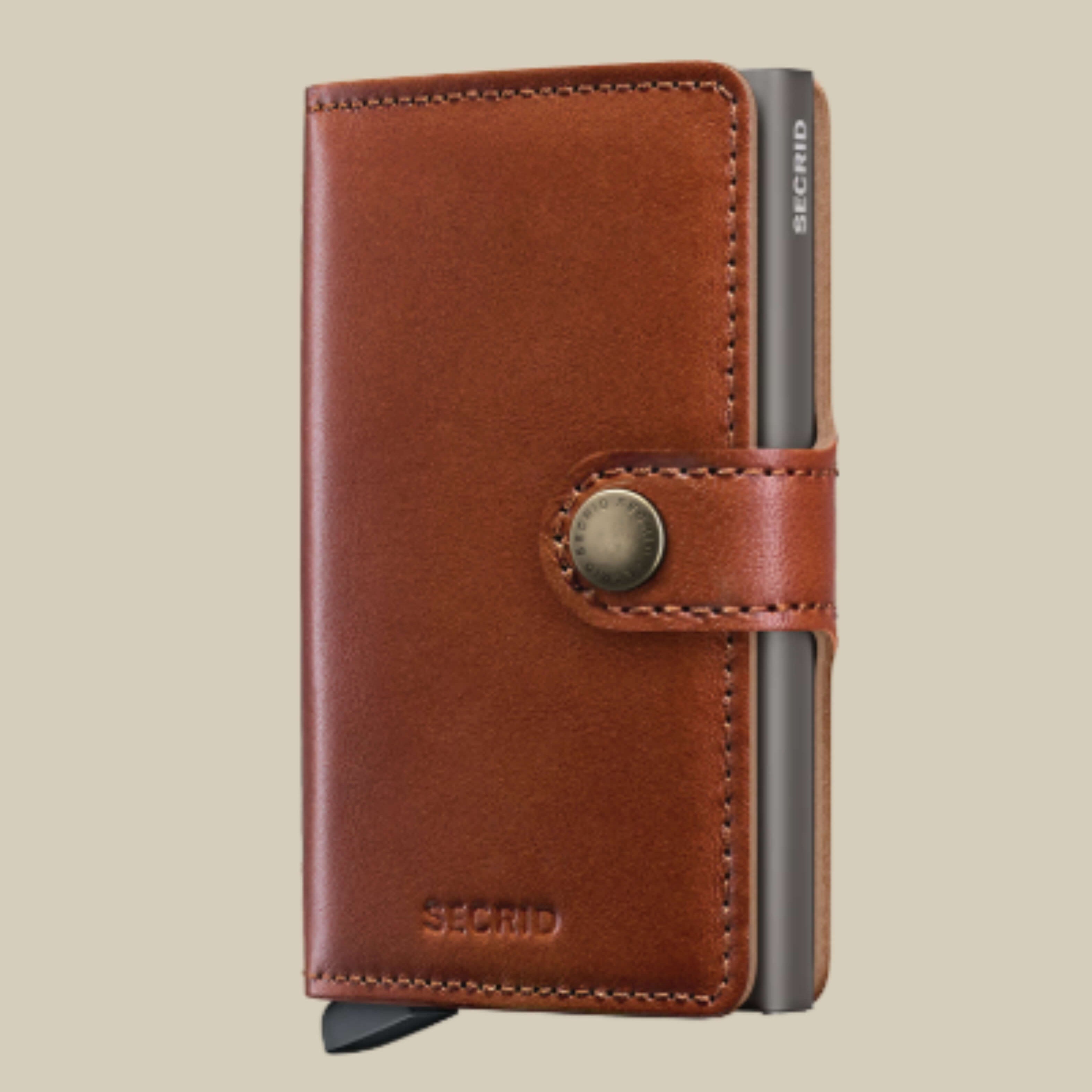 Brown leather wallet with metal clip on a beige background