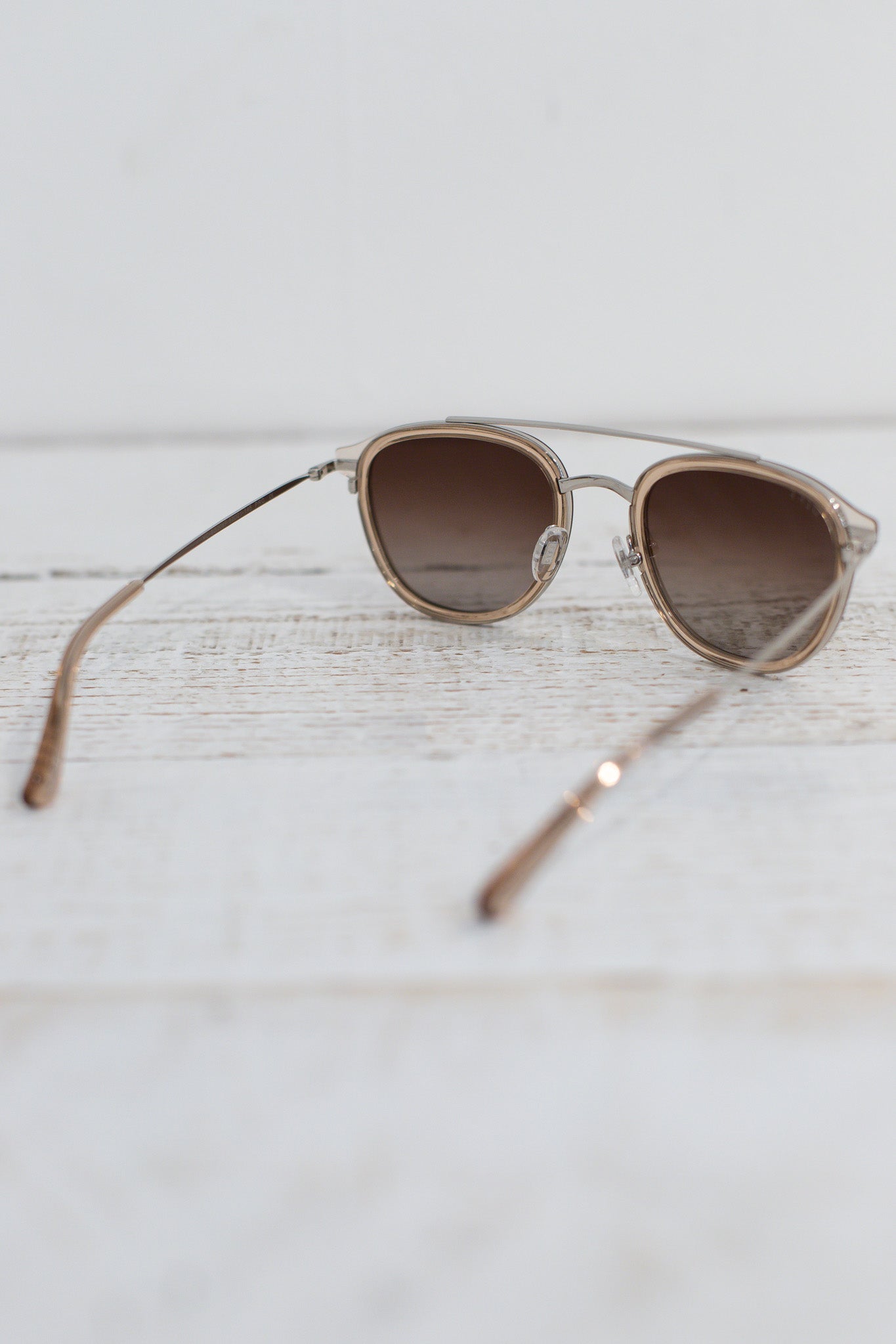 Sunglasses with brown lenses on a light wooden surface