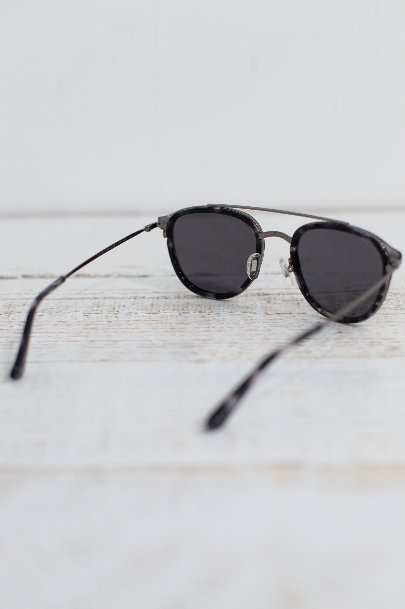 Black sunglasses on a light wooden surface
