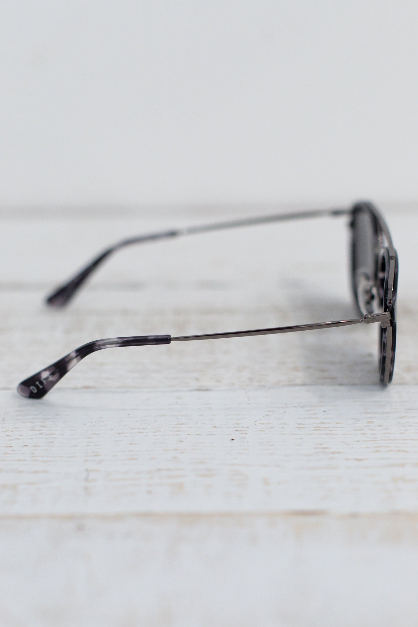 Sunglasses with tortoiseshell pattern on a light wooden surface